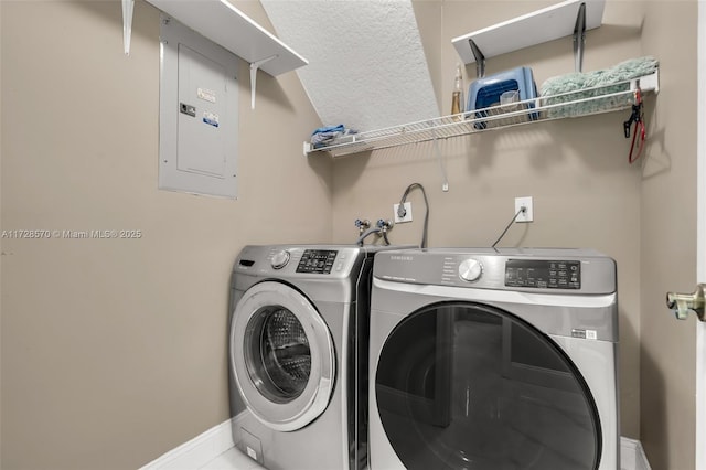 clothes washing area featuring electric panel, independent washer and dryer, and a textured ceiling