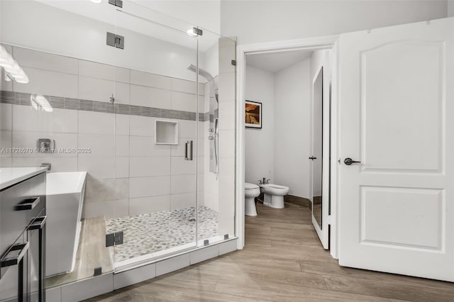 bathroom with a bidet, wood-type flooring, toilet, and a shower with shower door