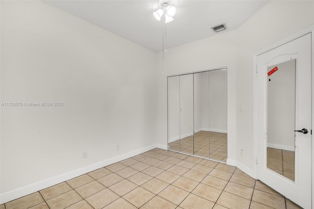 unfurnished bedroom with light tile patterned floors and a closet