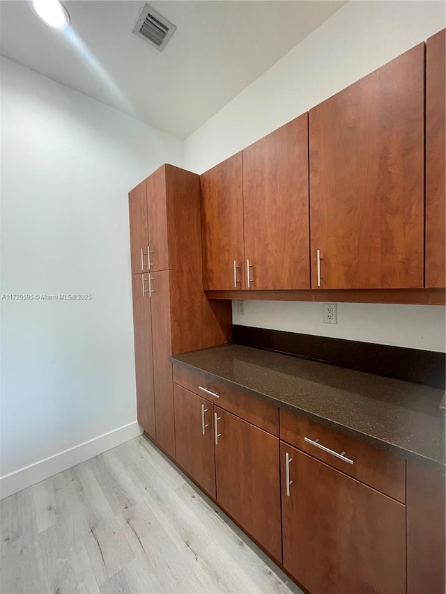 kitchen featuring light hardwood / wood-style flooring and dark stone counters