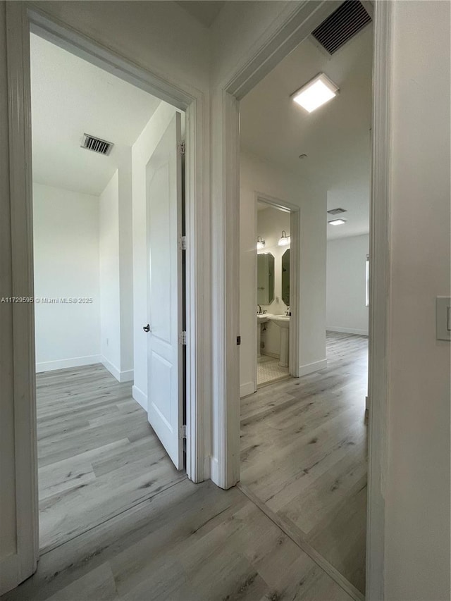 corridor with light hardwood / wood-style flooring