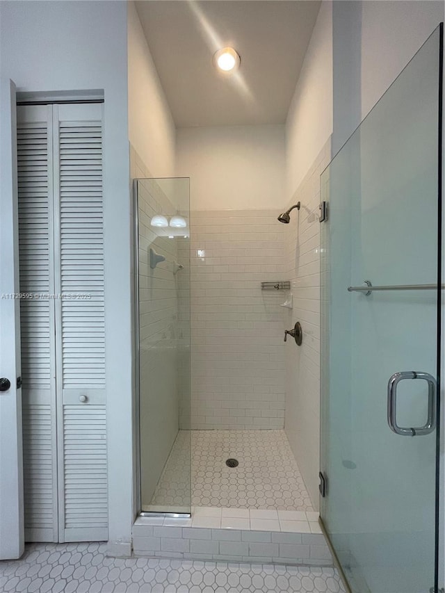 bathroom featuring an enclosed shower and tile patterned floors