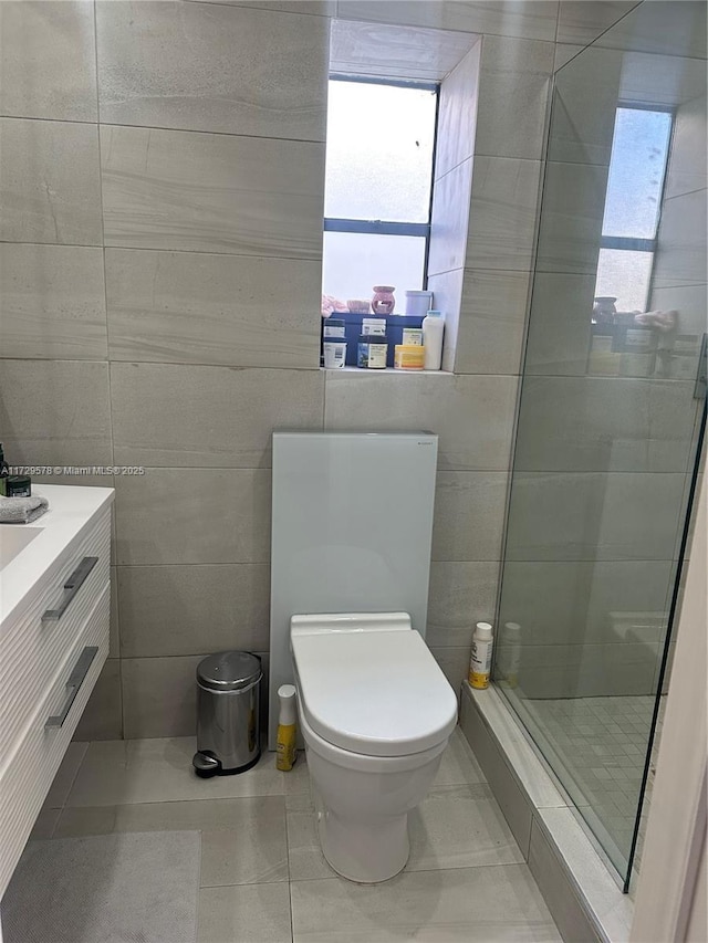 bathroom featuring vanity, tile walls, tile patterned floors, and toilet