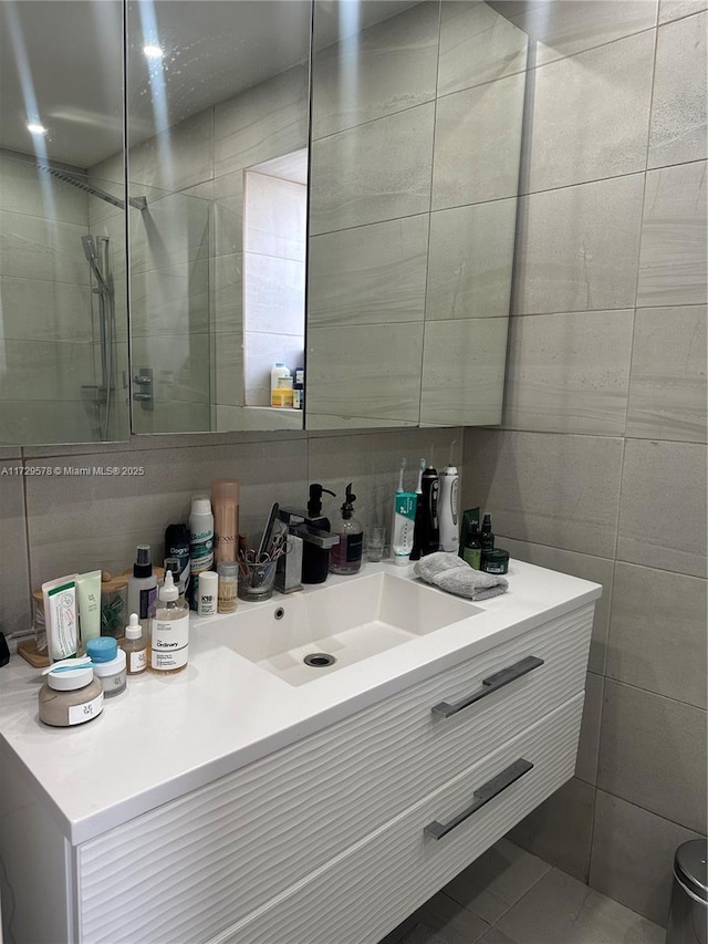 bathroom with vanity, tile walls, and walk in shower