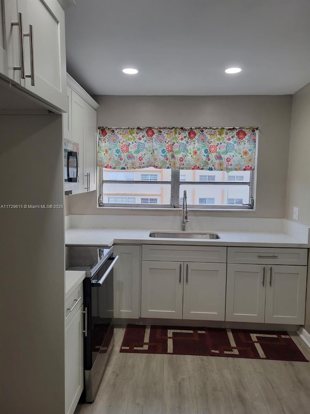 kitchen with white cabinetry, stainless steel appliances, dark hardwood / wood-style flooring, and sink