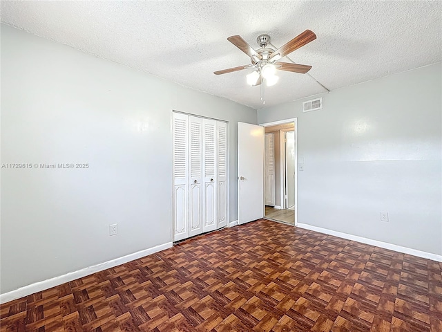 unfurnished bedroom with a closet, visible vents, a ceiling fan, a textured ceiling, and baseboards