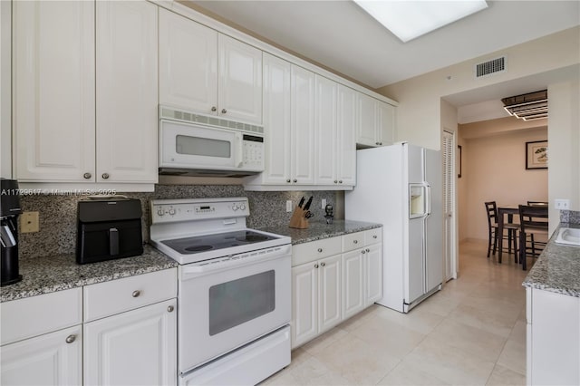 kitchen with light tile patterned floors, white cabinetry, tasteful backsplash, and white appliances