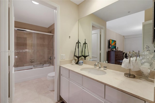 full bathroom featuring combined bath / shower with glass door, vanity, tile patterned floors, and toilet