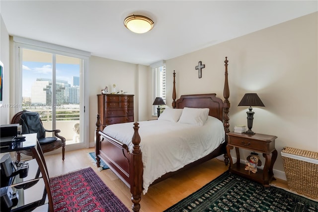 bedroom with light wood-type flooring, floor to ceiling windows, and multiple windows