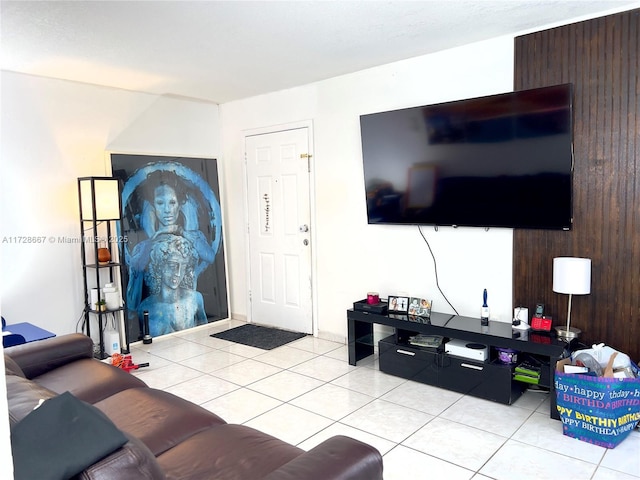 living room with wood walls and light tile patterned flooring