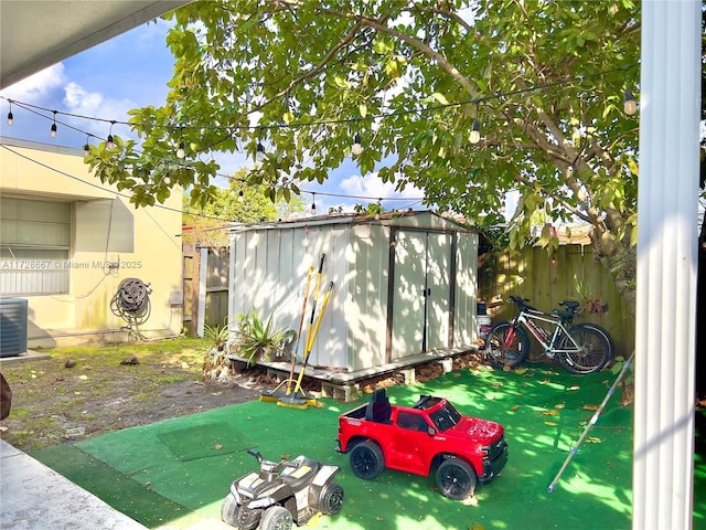 view of yard featuring central AC and a shed