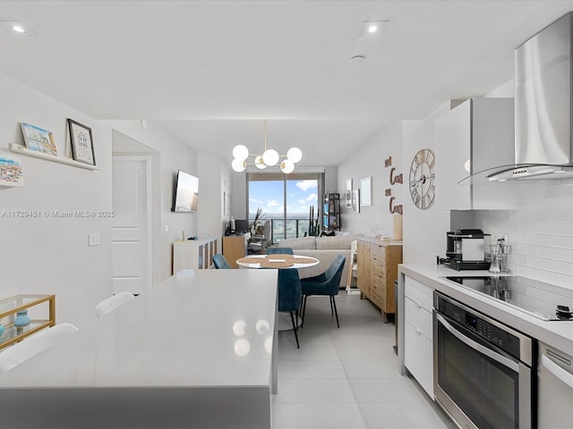 kitchen with stainless steel oven, black electric stovetop, white cabinets, ventilation hood, and backsplash