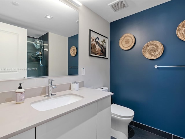 bathroom featuring vanity, toilet, tile patterned floors, and a shower with door