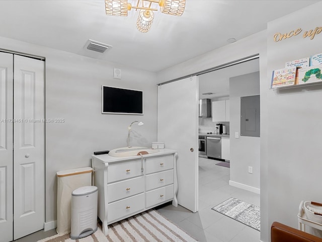 bedroom with sink, electric panel, and light tile patterned floors