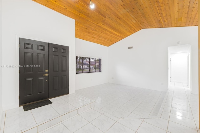 foyer entrance featuring high vaulted ceiling, light tile patterned floors, and wood ceiling