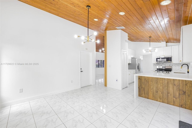 kitchen with wooden ceiling, pendant lighting, white cabinets, and stainless steel appliances