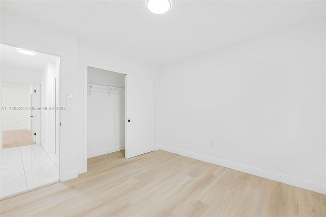 unfurnished bedroom featuring light hardwood / wood-style floors and a closet