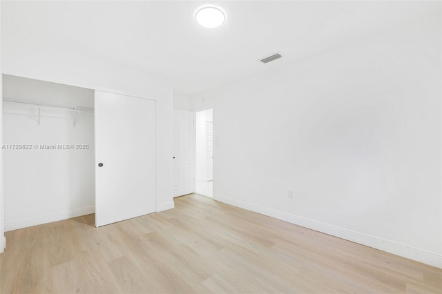 unfurnished bedroom with light hardwood / wood-style floors and a closet