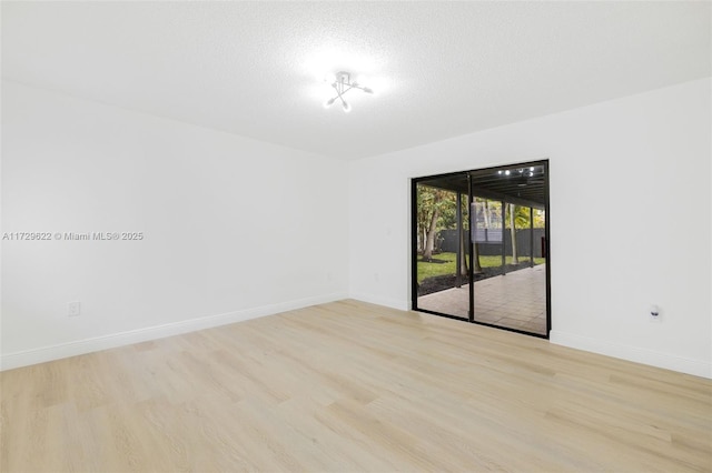 empty room featuring a textured ceiling and light hardwood / wood-style flooring