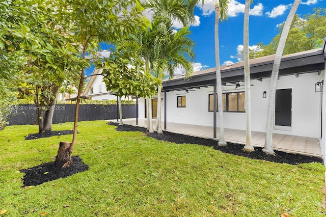 view of yard with ceiling fan and a patio