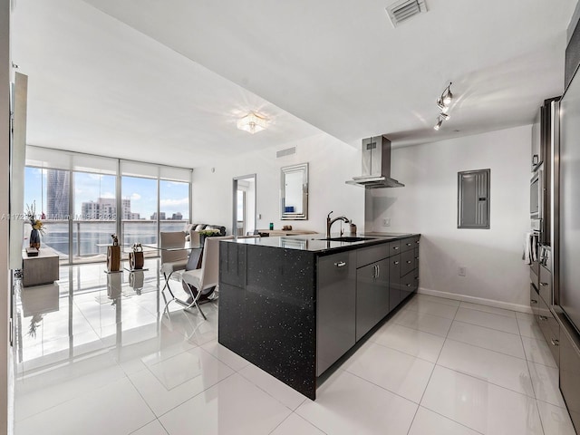 kitchen featuring ventilation hood, sink, floor to ceiling windows, and light tile patterned flooring