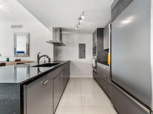 kitchen featuring built in fridge, extractor fan, sink, stainless steel oven, and light tile patterned floors