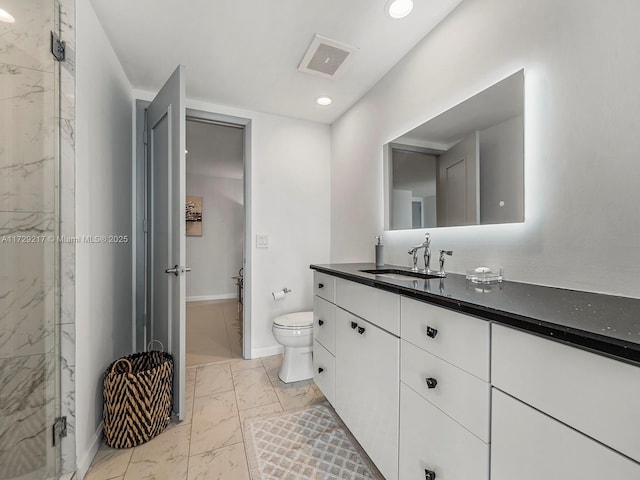 bathroom with toilet, vanity, and walk in shower