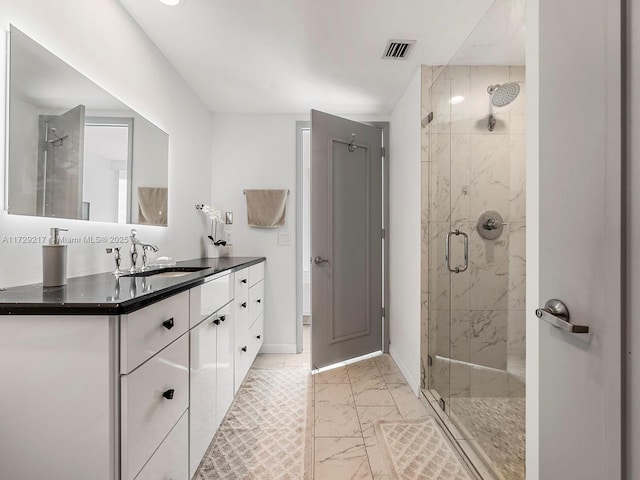 bathroom with vanity and a shower with door