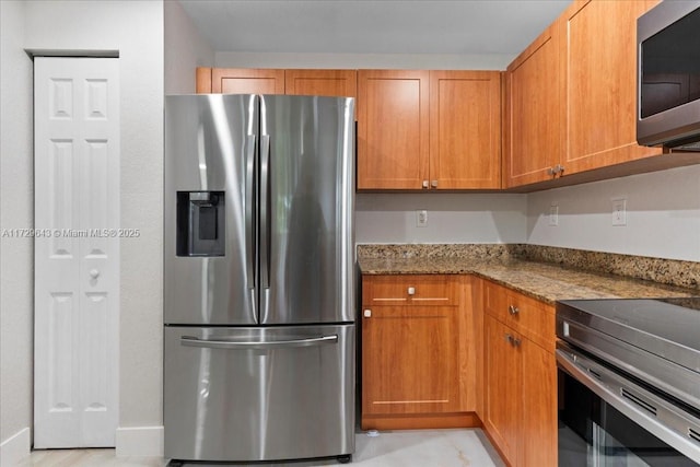 kitchen with dark stone countertops and stainless steel appliances