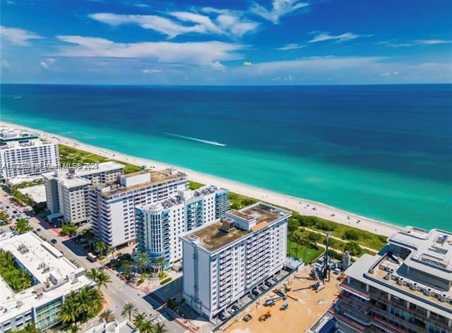 bird's eye view featuring a water view and a beach view