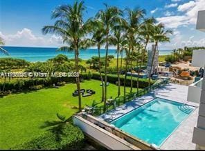 view of swimming pool featuring a water view, a patio, and a yard