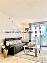 living room featuring a wall of windows and light tile patterned floors