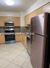 kitchen with light tile patterned floors and stainless steel appliances