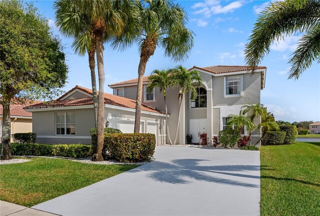 mediterranean / spanish house featuring a garage and a front yard