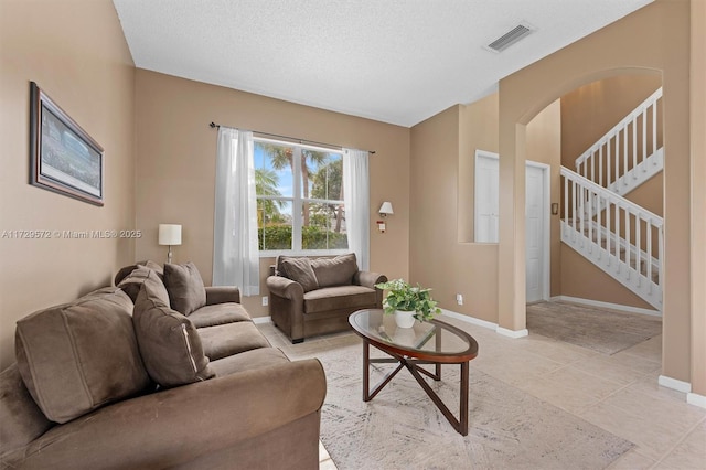 living room with light tile patterned flooring and a textured ceiling