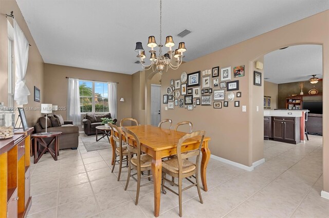 tiled dining room with an inviting chandelier