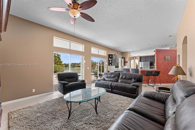 tiled living room featuring a textured ceiling and ceiling fan