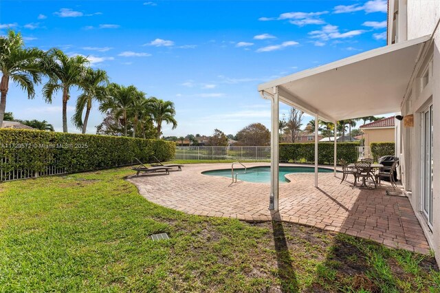 view of pool with a patio area and a lawn