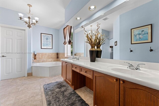 bathroom featuring tiled bath, tile patterned flooring, a chandelier, and vanity