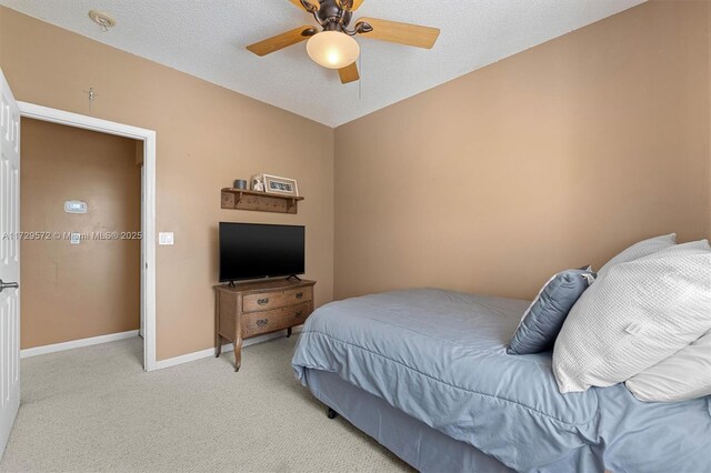 carpeted bedroom featuring a textured ceiling and ceiling fan