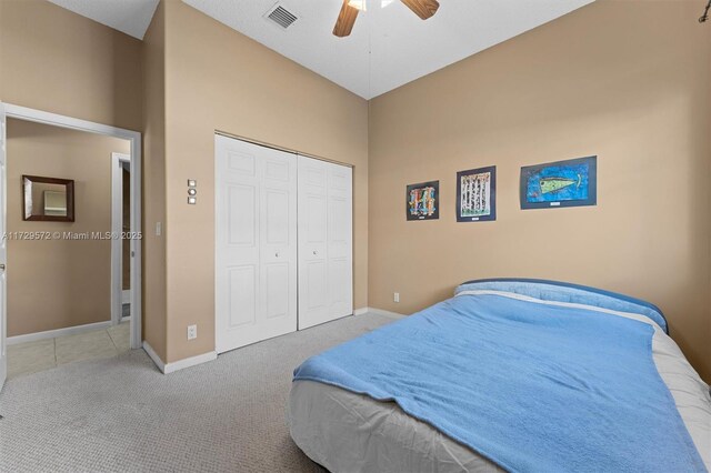 bedroom with ceiling fan, a closet, and light carpet