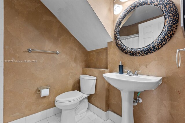 bathroom featuring vaulted ceiling, toilet, and tile patterned flooring