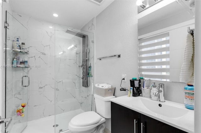 bathroom with toilet, a shower with door, and vanity