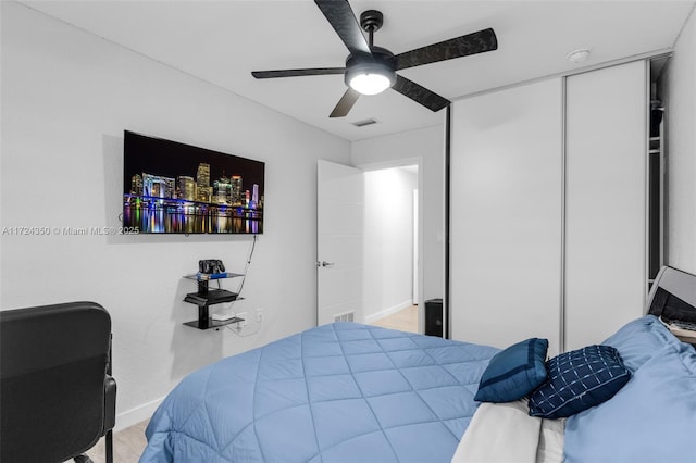 bedroom with ceiling fan, hardwood / wood-style flooring, and a closet