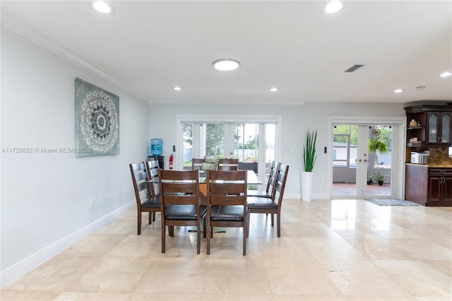 dining space featuring french doors and crown molding