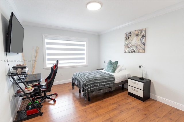 bedroom with crown molding and light hardwood / wood-style floors