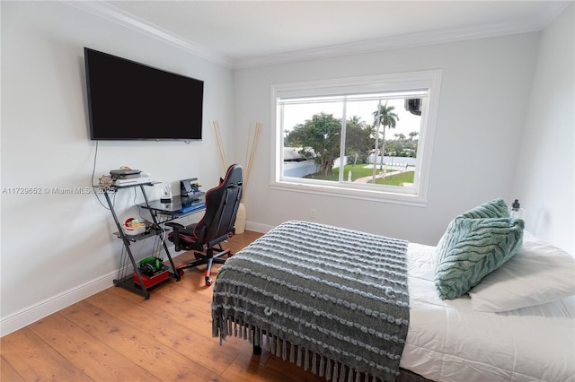 bedroom featuring wood-type flooring and ornamental molding