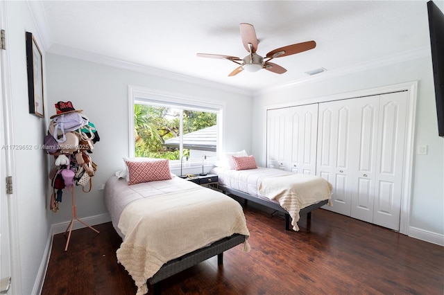 bedroom featuring crown molding, dark wood-type flooring, ceiling fan, and a closet