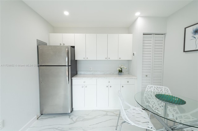 kitchen with white cabinetry and stainless steel fridge