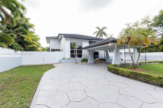 back of house featuring a carport and a yard